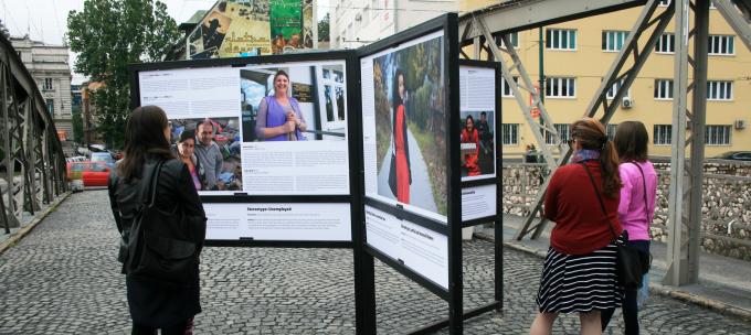 Three women review an exhibition on the Roma people in Sarajevo.
