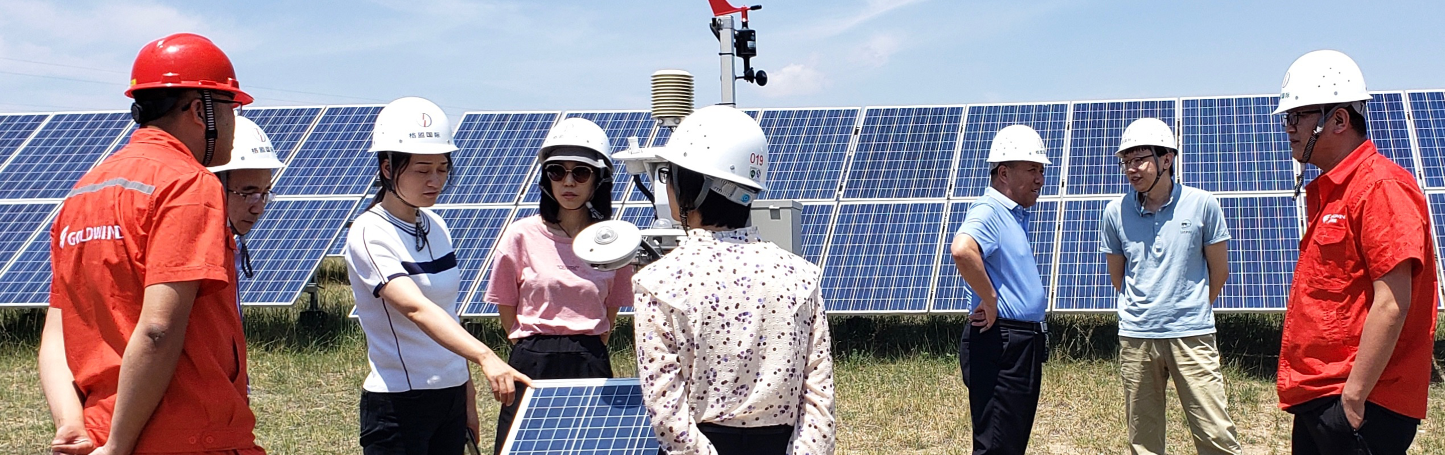 Men and women examine a solar energy array.