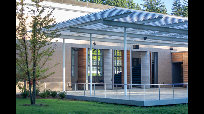 The terrace of David Rockefeller Creative Arts Center with pivot doors open revealing performance space inside.