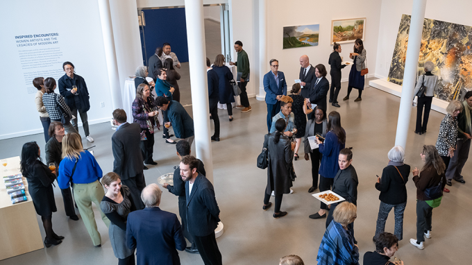 peple mingle in the reception area of the DR Center surrounded by art