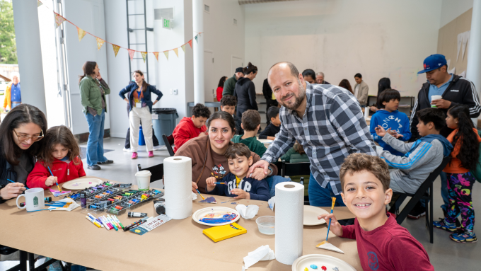 Families and children paint together 