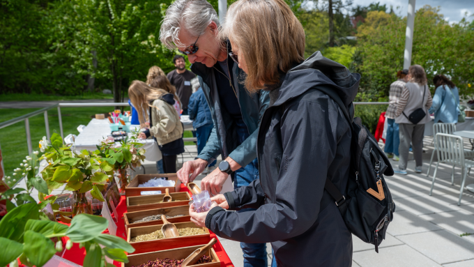Two people make herb sachets at the MET Cloisters table.