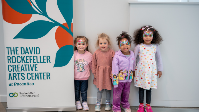 4 children stand in front of the David Rockefeller Creative Arts Center sign