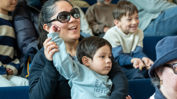 Mother and son sit together enjoying a performance
