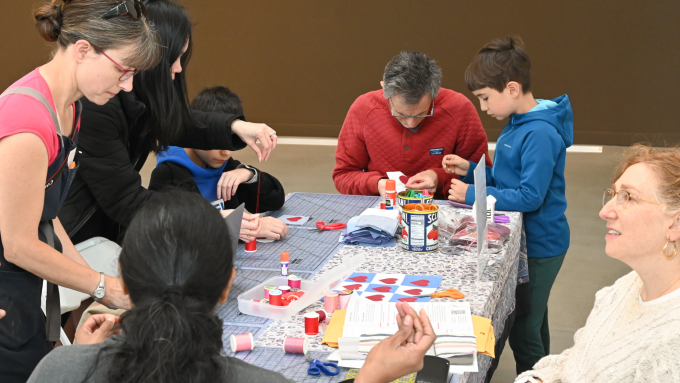 Families sit together and sew hearts with Neptune in June