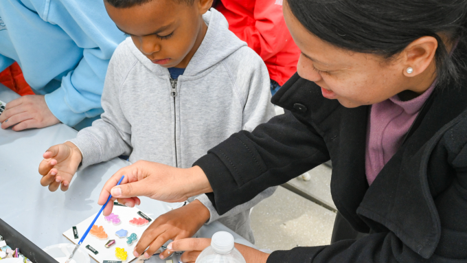 Mother and son make tiled poetry mosaic art at a table