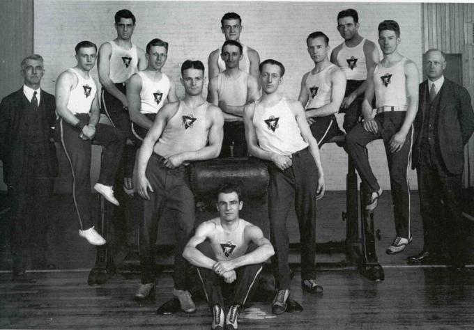 Black and white photo of a group of men wearing YMCA t-shirts.