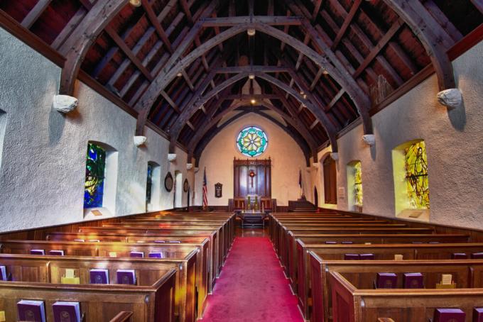 The interior of a church featuring a circular stained glass window.