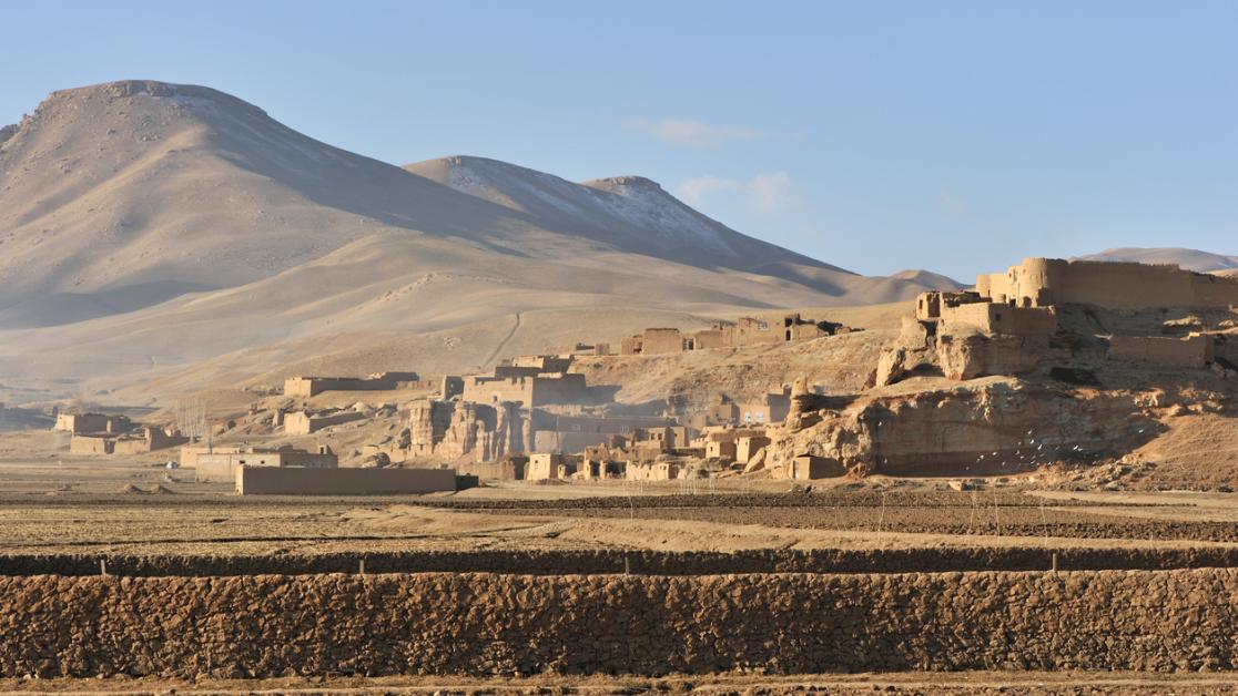 A sandstone village surrounded by desert and mountains