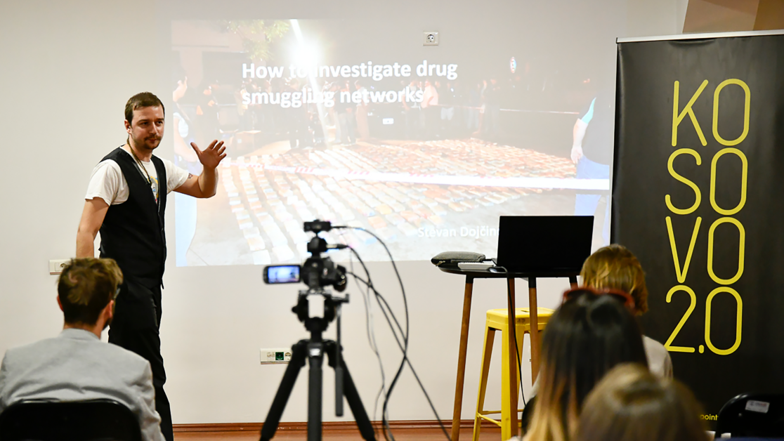 a camera films a man presenting on how to investigate smuggling networks