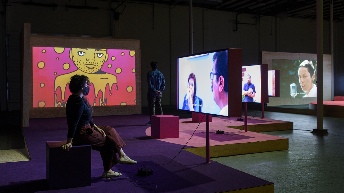People look at video screens as part of an art installation