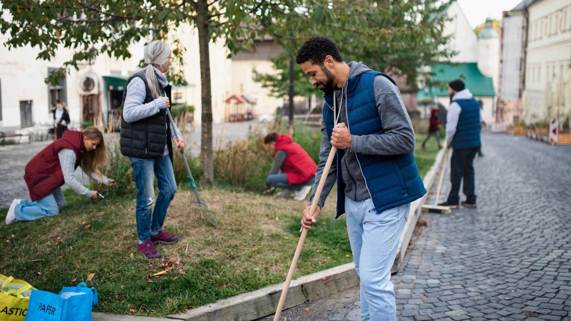 People of different ages, races, and genders work together to care for a community park.