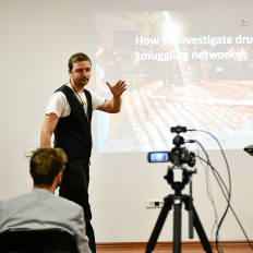 a camera films a man presenting on how to investigate smuggling networks