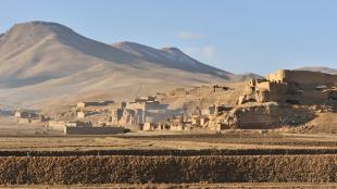 A sandstone village surrounded by desert and mountains