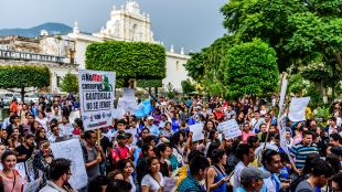 Protestors wave Guatemalan flags and slogans protesting government corruption in front of Antigua city hall. Sign reads "No more corruptionists. Guatemala isn't for sale".