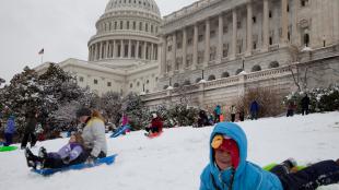 Children and families sled on the snow-covered lawn of the US Capitol building in 2014.