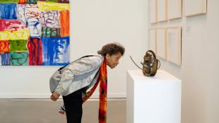 Woman looks at a sculpture in the Inspired Encounters Exhibit of the DR Center