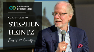 A portrait of Stephen Heintz holding a microphone with the text, "congratulations Stephen heintz, President Emeritus of the Rockefeller Brothers Fund"