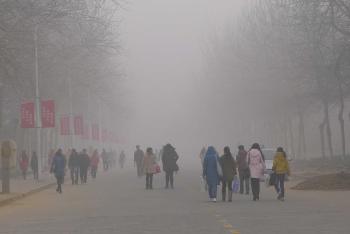 students walk through a smog-filled campus