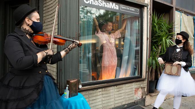 Musicians play outside a vacant store front in New York.