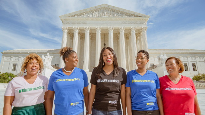 Five women in front of the U.S. Supreme court wearing shirts that say #blackwomenvote
