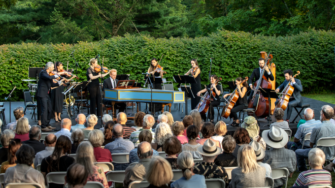 An orchestra performs outdoors