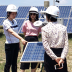 Men and women examine a solar energy array.
