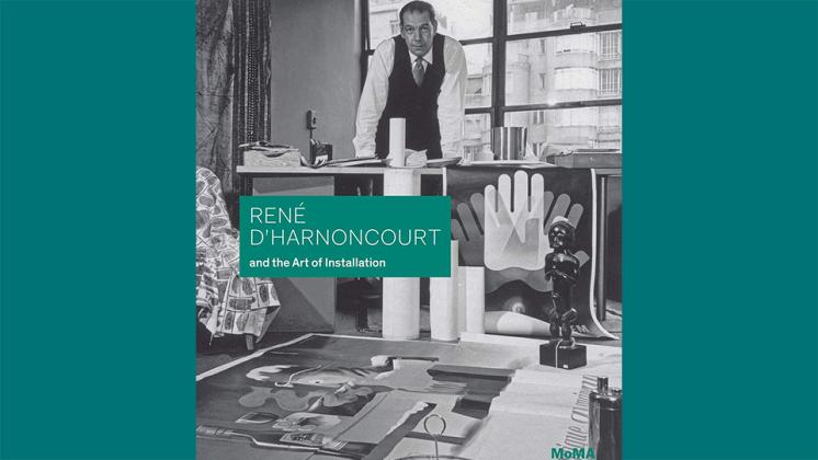 The cover of Elligott's book, a black and white photo of D'Harnoncourt standing behind a desk in a room full of posters from MoMA's exhibitions.