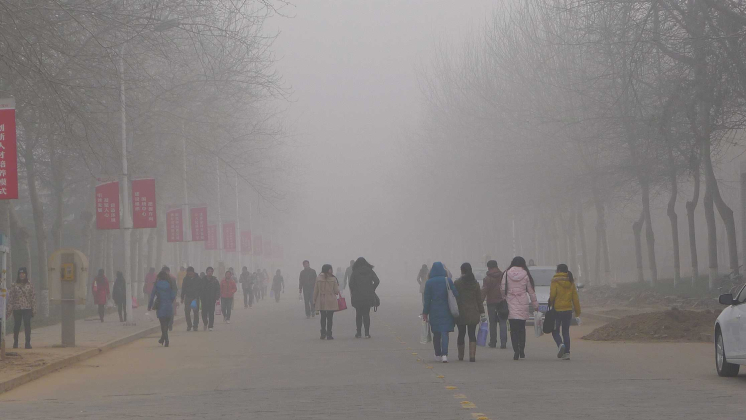 students walk through a smog-filled campus